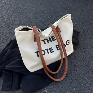 Minimalist canvas tote bag with brown leather straps and text print for women
