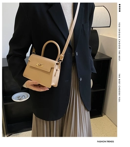 Vue détaillée d'un sac à main beige en cuir avec fermoir doré et bandoulière réglable