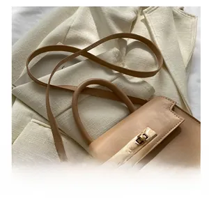 Détail de la bandoulière confortable et du cuir beige lisse de ce sac à main chic