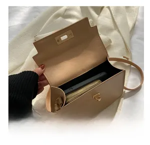 Vue intérieure d'un sac bandoulière beige montrant l'espace pour téléphone et grand portefeuille