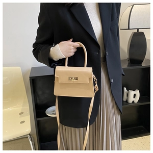 Détail du sac bandoulière français avec fermoir rotatif en métal doré et poignée en cuir