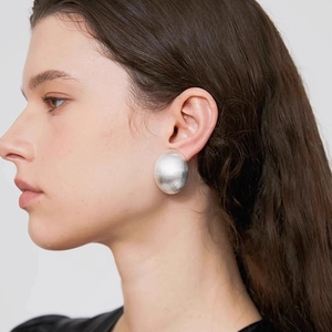 Boucles d'oreilles argent mat de style français avec finition brossée sur mannequin femme