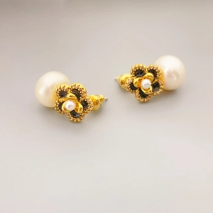 Elegant gold flower earrings with black enamel petals, shimmering crystals, and white pearls