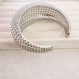 Silver open bangle with beaded texture and hollow grid structure in jewelry box