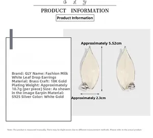 Detail of leaf-shaped brass earring with 18K gold plating and cream enamel drip finish