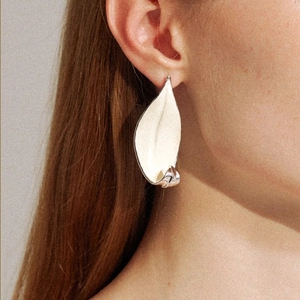 Elegant plant series cream white leaf stud earring with silver edges on a model's ear