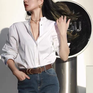 Chemisier blanc à col montant minimaliste avec collier en cuir et jean taille haute