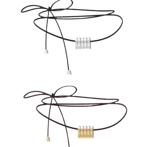 Détail de colliers en cordon minimalistes avec pendentifs en métal argenté et doré