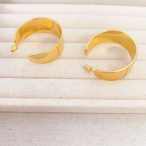 Vue détaillée de boucles d'oreilles dorées larges en C avec finition miroir polie