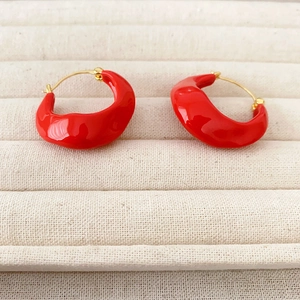 Macro shot of irregular red enamel thick hoop earrings with gold-plated metal needles