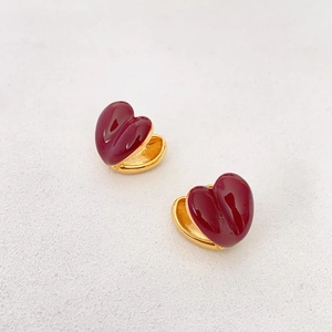 Elegant heart-shaped hoop earrings in deep wine red enamel finish with golden metal base