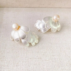 Elegant silver layered petal earrings with freshwater pearls on a neutral linen background