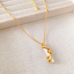 French vintage baroque pearl necklace with golden spiral wrap pendant on cream jewelry box
