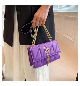 Detailed view of purple quilted chain bag with gold SS logo and elegant tassel