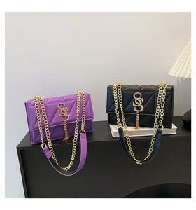 Detail of quilted chain crossbody bags in purple and black with gold hardware and tassels