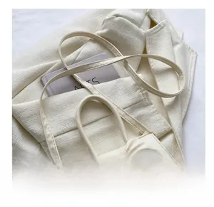 Detail of adjustable PU leather strap and metal buckle on cream crossbody bow bag