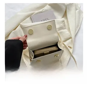Detail view of white PU crossbody bag interior showing storage space for a wallet