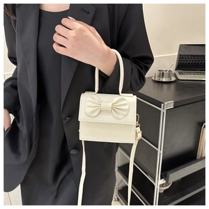 Dettaglio mini borsa bianco crema con fiocco 3D e tracolla regolabile in pelle PU
