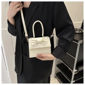 Dettaglio mini borsa in pelle PU bianco crema con fiocco 3D ed elegante manico corto