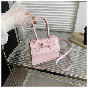 Dettaglio di una mini borsa rosa con fiocco 3D e raffinato manico superiore