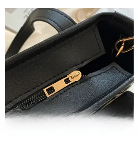 Detail of premium golden zipper and houndstooth texture on this stylish handbag