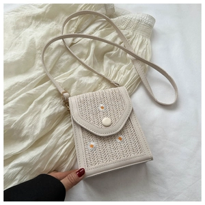 Detail of cream woven shoulder bag featuring delicate white daisy floral embroidery