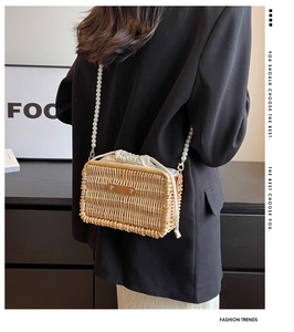 Detail of woven rattan bag with white pearl shoulder strap and drawstring lining