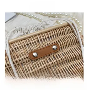 Close-up of woven rattan bag texture with leather patch, silver rivets and drawstring liner