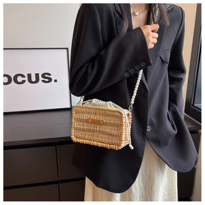 Detail of hand-woven rattan bucket bag featuring pearl bead handle and canvas drawstring