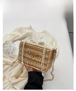 Detail of woven rattan box bag with drawstring lining and gold chain strap