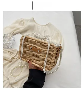 Detail of woven rattan bag featuring pearl strap, leather accents, and drawstring closure