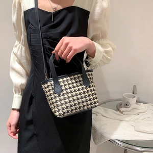 Classic houndstooth bucket bag with black leather trim shown in a chic casual outfit