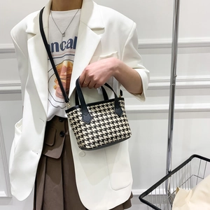 Classic houndstooth tote bag with black leather straps shown in hand for daily commute