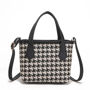 Classic black and white houndstooth tote bag with leather handles and adjustable strap