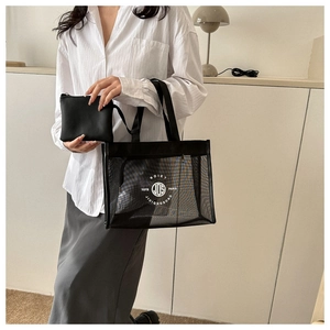 Detail of black mesh tote bag with inner pouch and white printed text for beach use