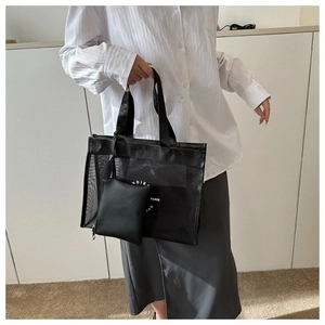 Detailed view of black mesh tote bag with white Paris print and small inner pouch