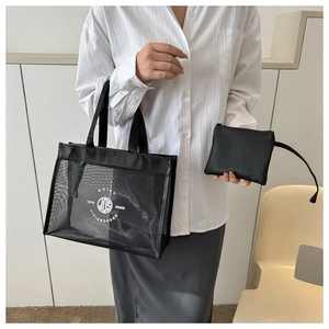 Detail of black mesh tote bag with white circular logo and matching inner leather pouch