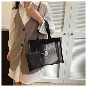 Detail of black mesh tote bag with inner pouch and white circular logo on front