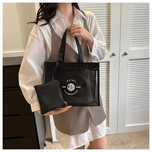 Close-up of black mesh tote bag with vintage circular logo and matching small pouch