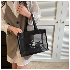 Detail of black mesh tote bag with circular white logo print and matching inner pouch