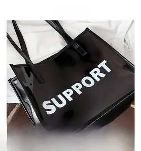 Detail of black translucent PVC tote bag featuring white SUPPORT lettering and slim handles