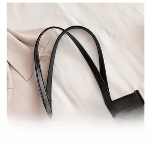 Detail of comfortable black leather shoulder strap and neat stitching on a PVC tote bag