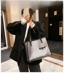 Detail view of transparent PVC tote bag with black SUPPORT logo and shoulder straps
