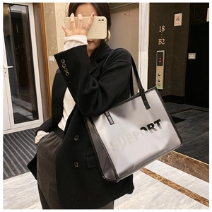 Detail of translucent PVC tote bag with black SUPPORT print and leather handles