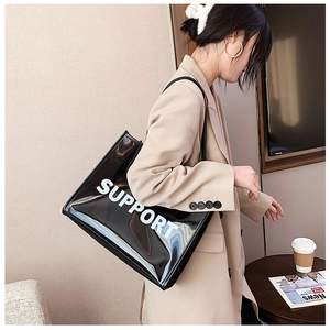 Detail of a black transparent PVC tote bag with white SUPPORT lettering on a model
