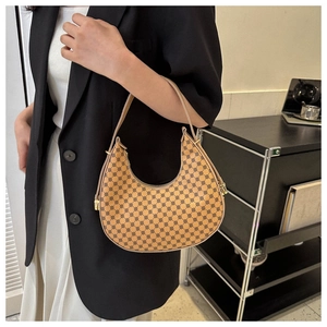Nahaufnahme der sichelförmigen Schultertasche mit geometrischem Muster und Goldzipper