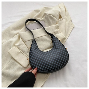 Details der schwarzen Halbmond-Tasche mit blauem Muster auf weißem Blazer