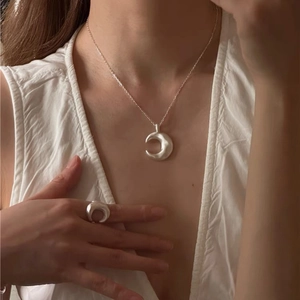 Minimalist matte silver moon necklace and ring set on model for a modern look