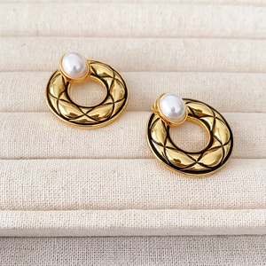 French vintage quilted gold earrings with elegant pearls on a jewelry display tray