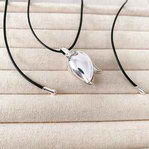 Minimalist silver tulip pendant necklace with polished flower bud on black cord